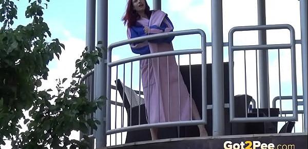  Redhead pees over her balcony in the city